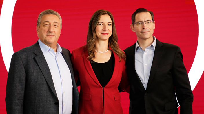 Barry Ritholtz (left), Rebecca Choo Quan (center), and Joe Davis (right) standing side by side in front of a red background.
