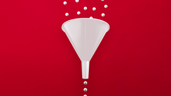 A white funnel on a red background with white spheres falling into the top and emerging from the bottom in a single stream, illustrating a filtering or selection process.